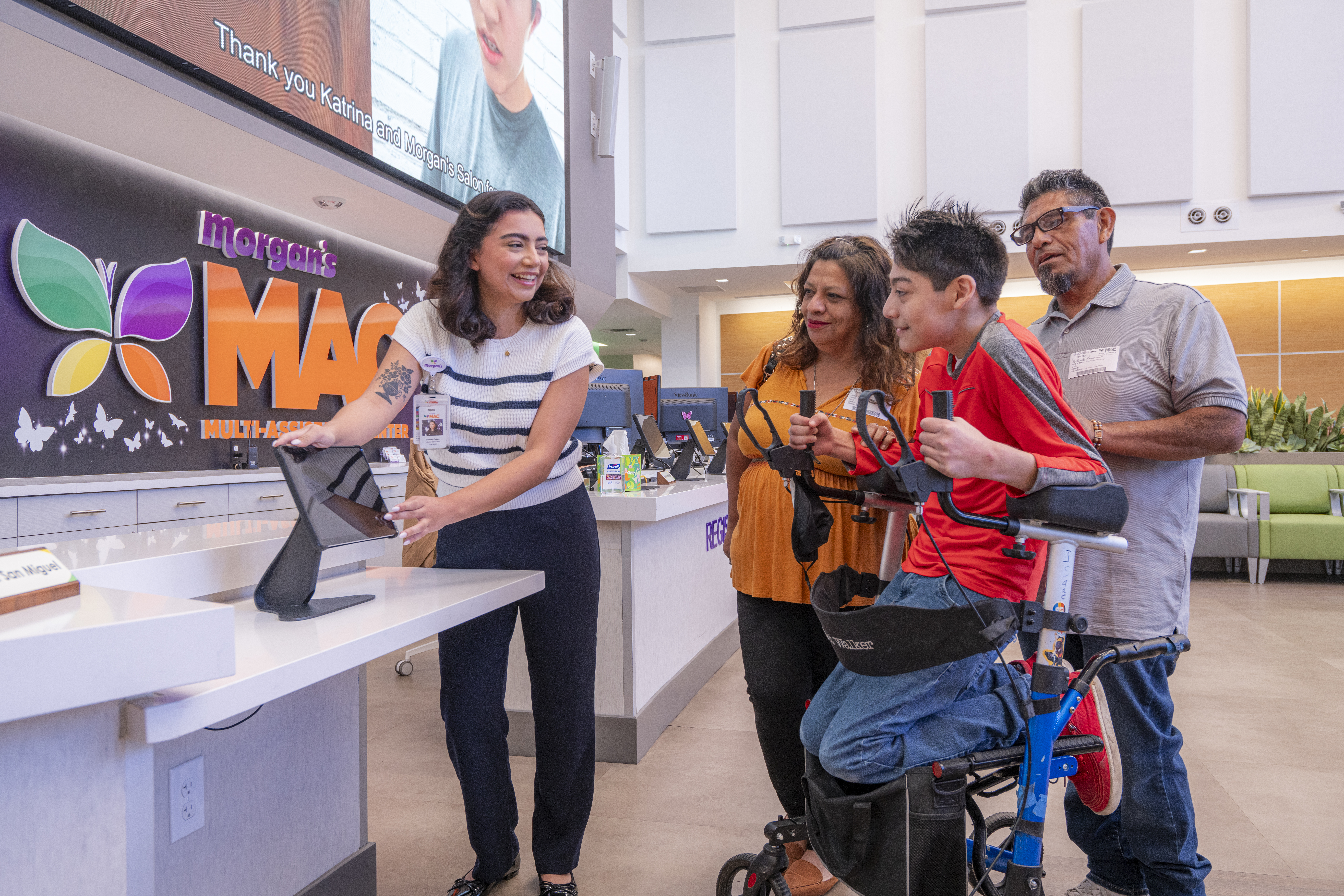 A woman greets a family in the lobby of Morgan's MAC in San Antonio.