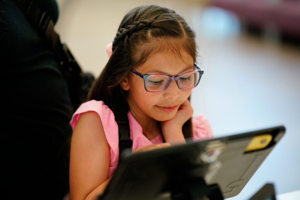 A young Morgan's MAC member uses a tablet while participating in activities at the Multi-Assistance Center.